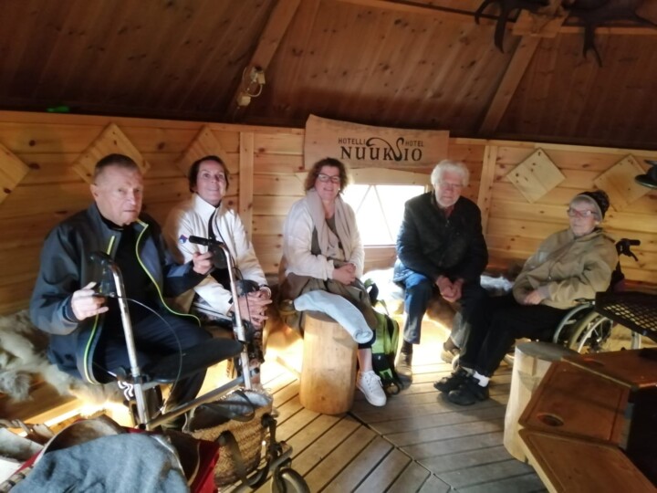 Viisi henkilöä istuu puoliympyrän muodossa kodassa.